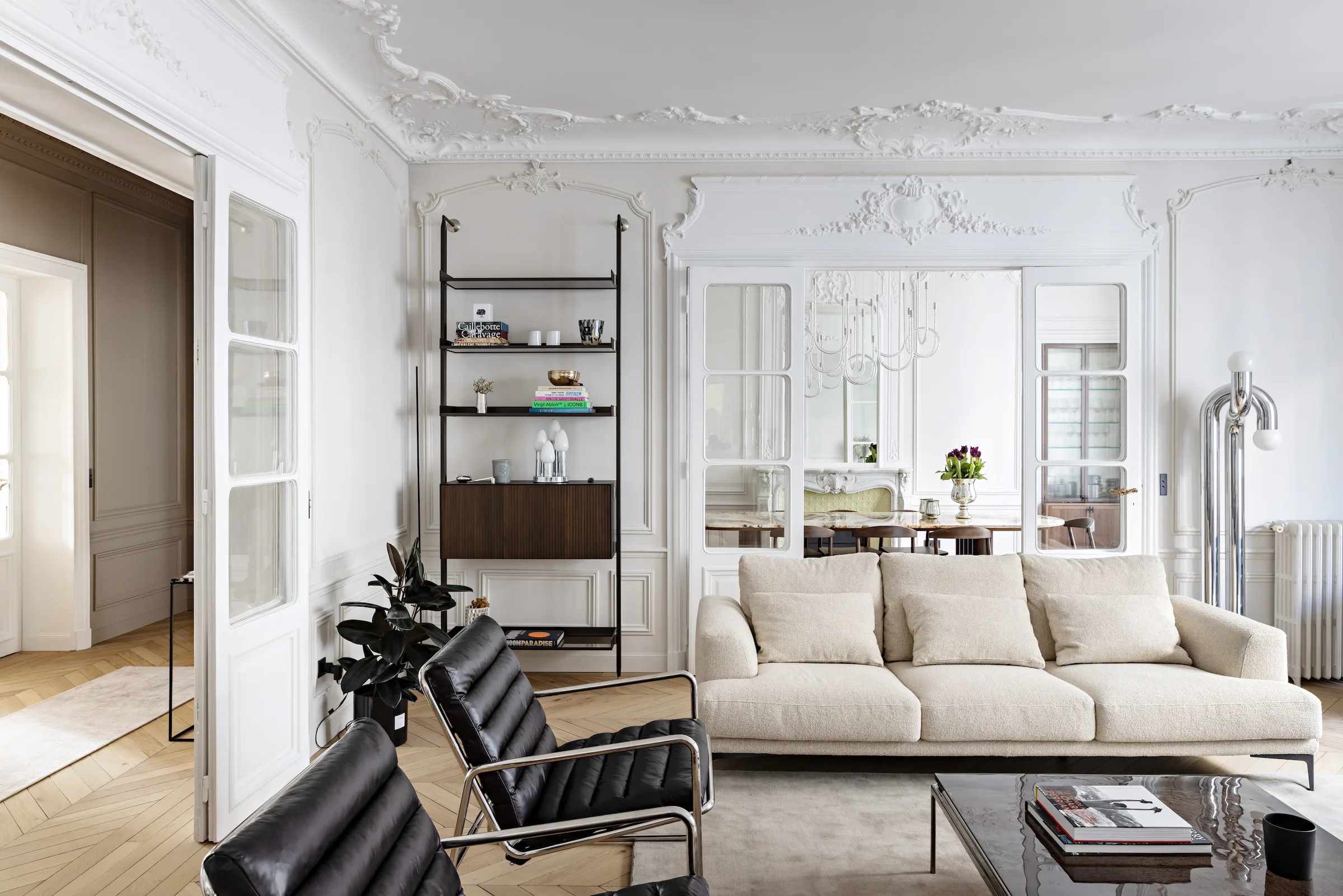 Salon d'un appartement haussmannien rénové par CETEG, moulures conservées et parquet en chevrons
