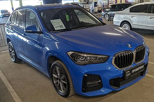 Zijaanzicht van een zilveren BMW X1 geparkeerd op straat
