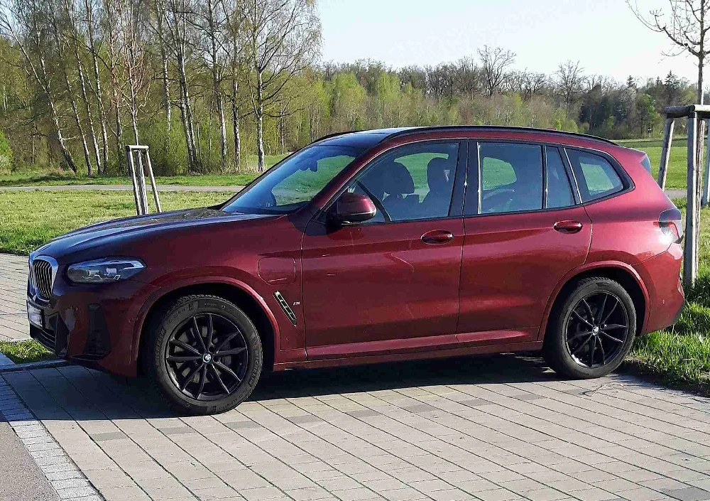 Zijaanzicht van een elektrische BMW ix3 die klaarstaat voor verkoop.