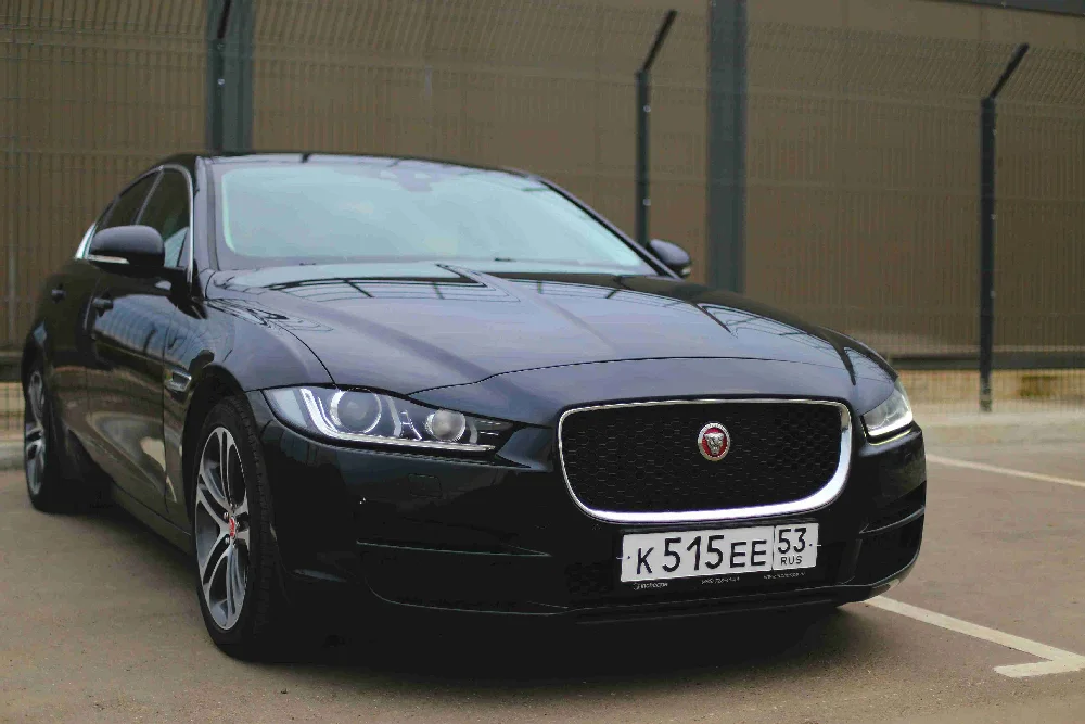 Zwarte Jaguar XE sedan geparkeerd langs de weg.