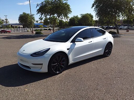 Witte Tesla Model 3 geparkeerd op een nette locatie.