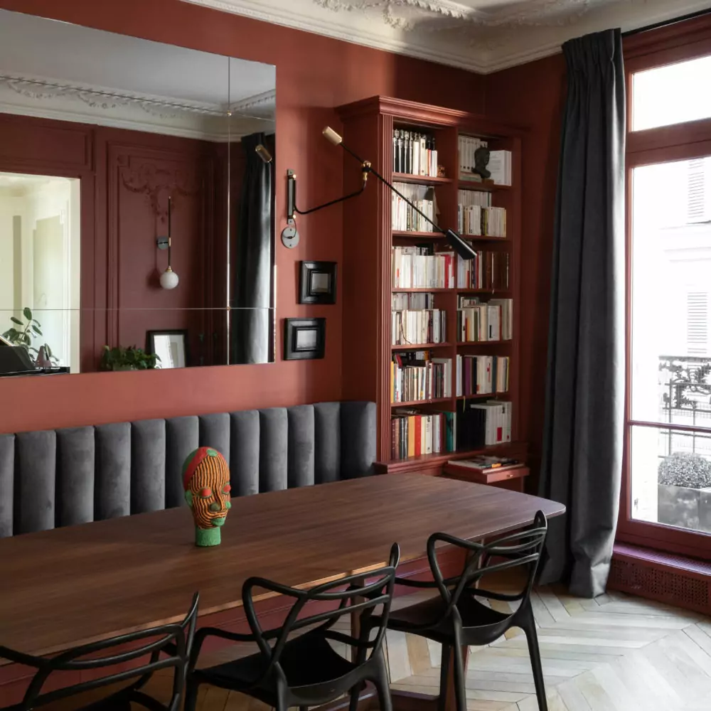 Aménagement intérieur – Salle à manger élégante avec murs rouges et bibliothèque – Projet Bellechasse CTEG