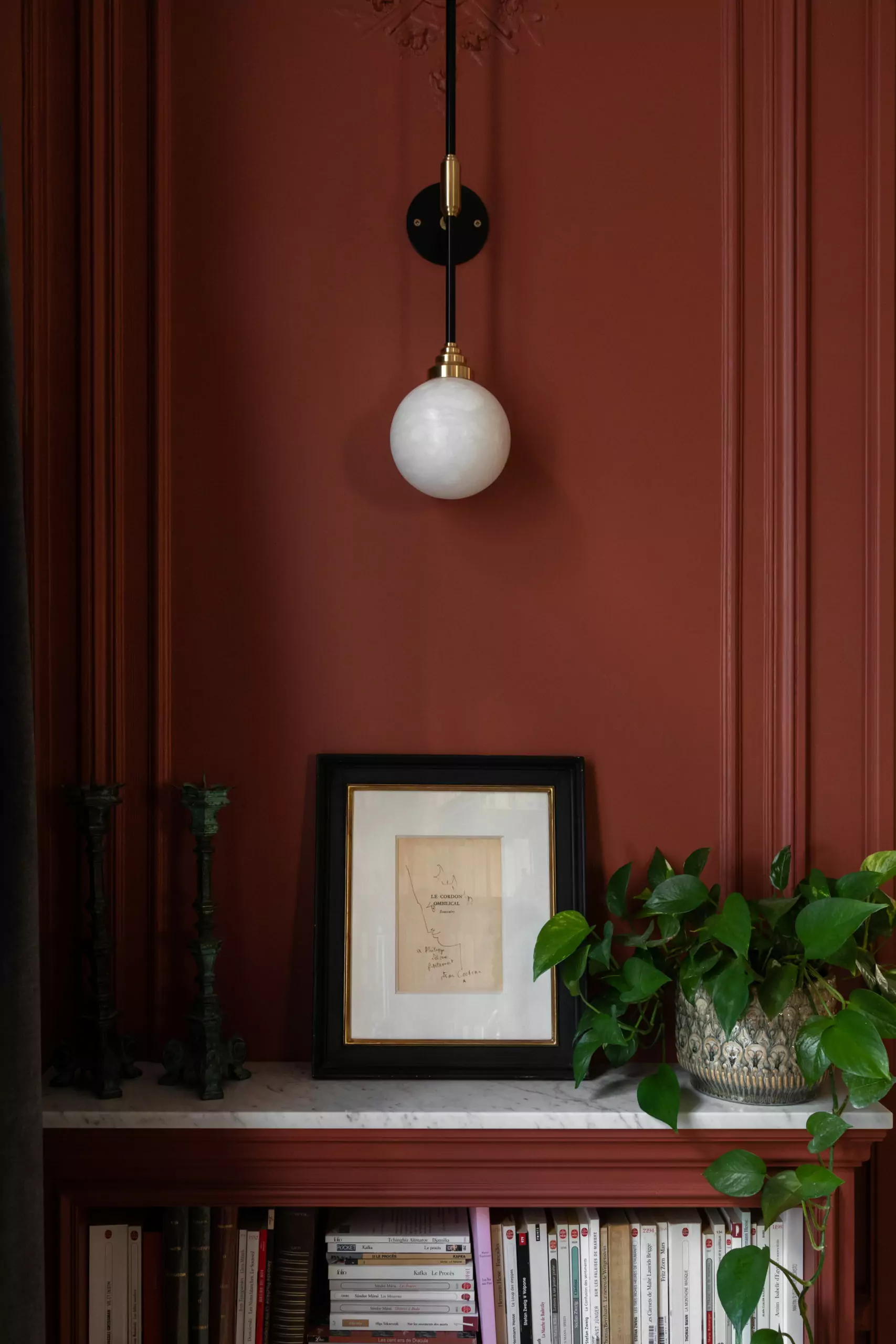 Aménagement intérieur – Détail décoratif sur mur rouge avec suspension – Projet Bellechasse CTEG