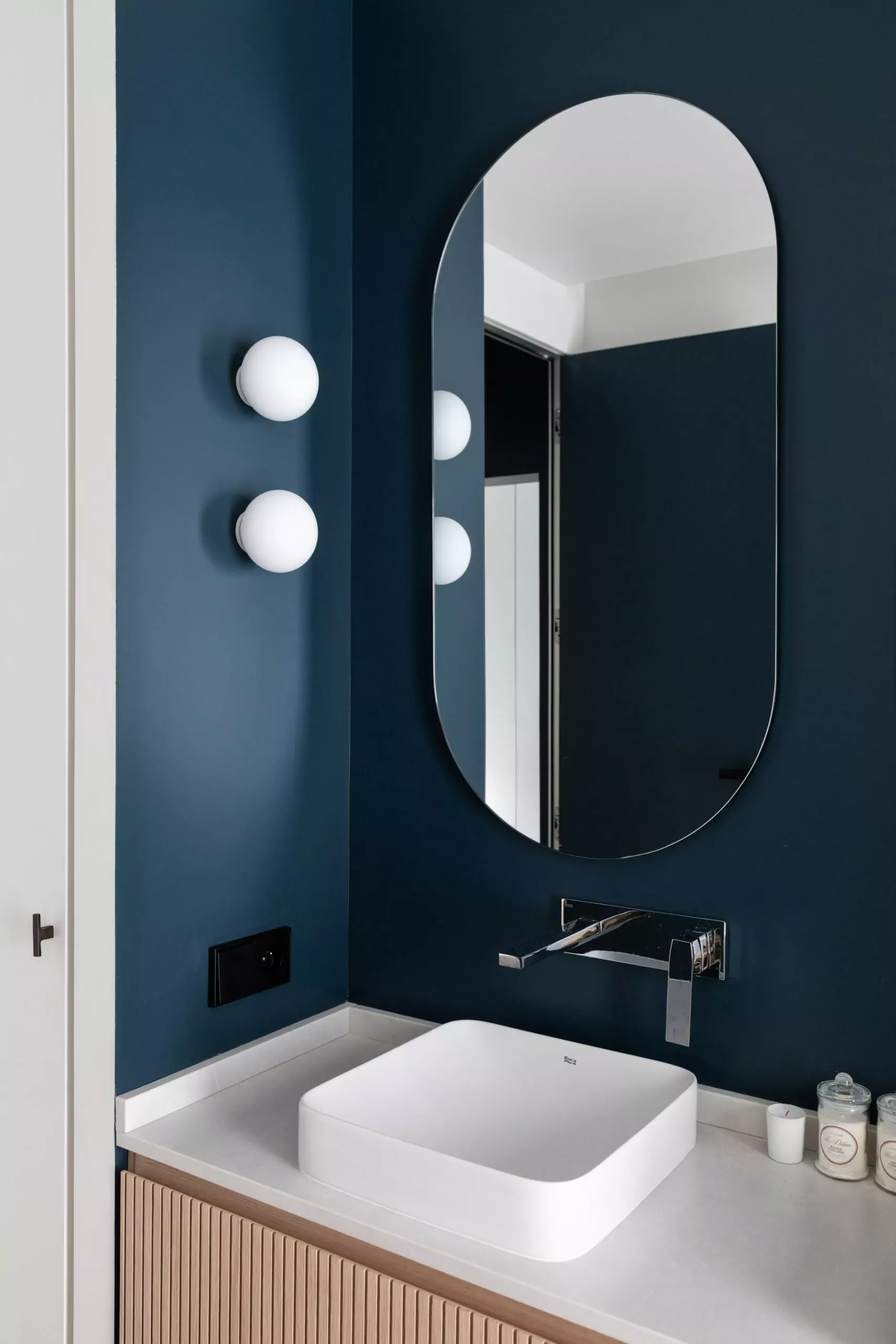 Aménagement intérieur – Salle de bain moderne avec murs bleus et miroir ovale – Projet Grenelle CTEG