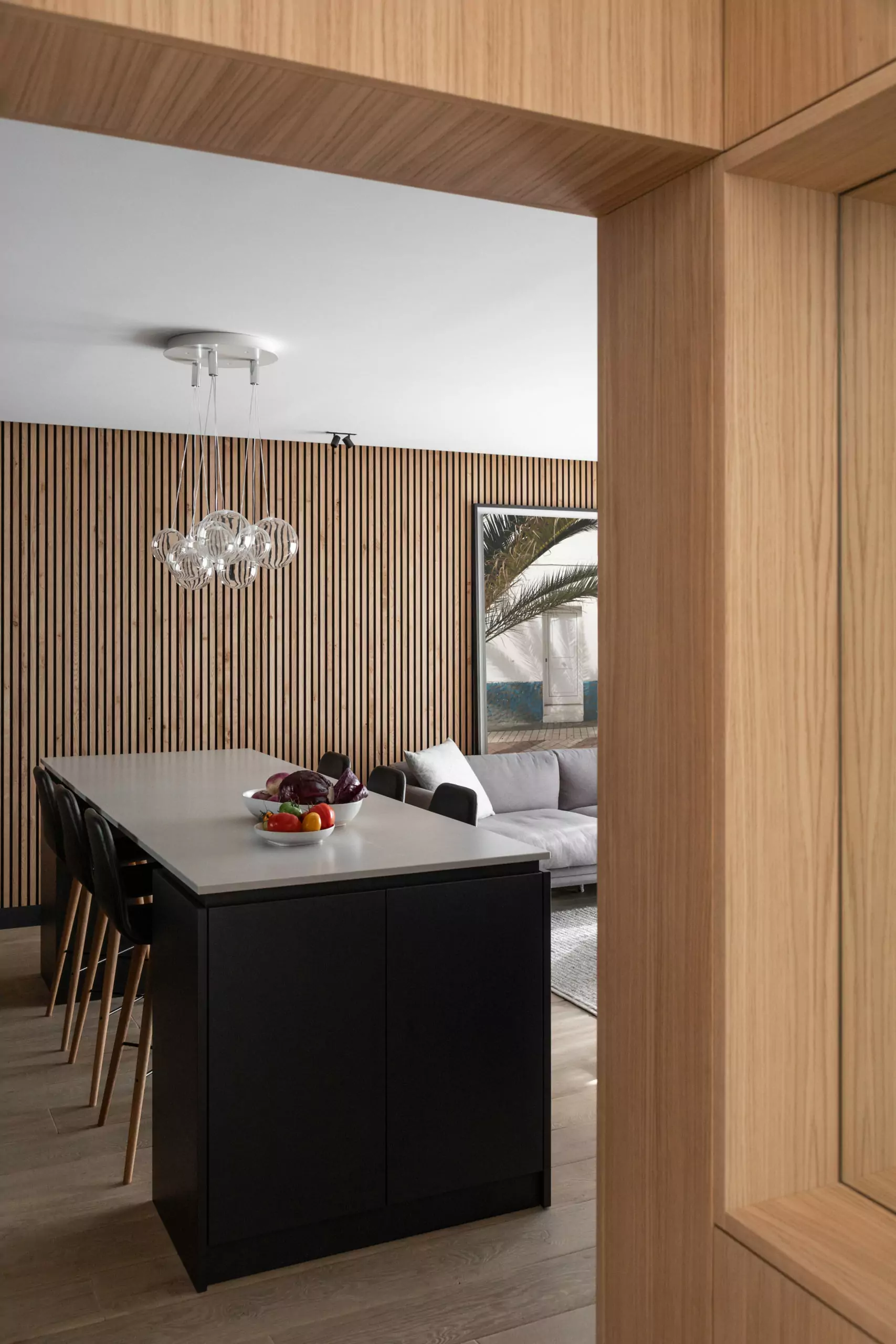 Aménagement intérieur – Salon avec claustra bois et canapé sombre – Projet Grenelle CTEG