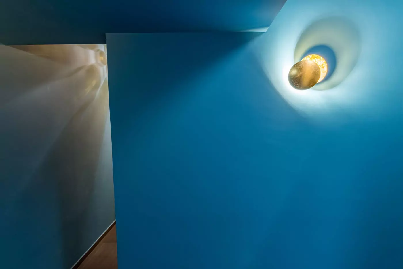 Aménagement intérieur – Mur bleu avec applique moderne – Projet Alma CTEG