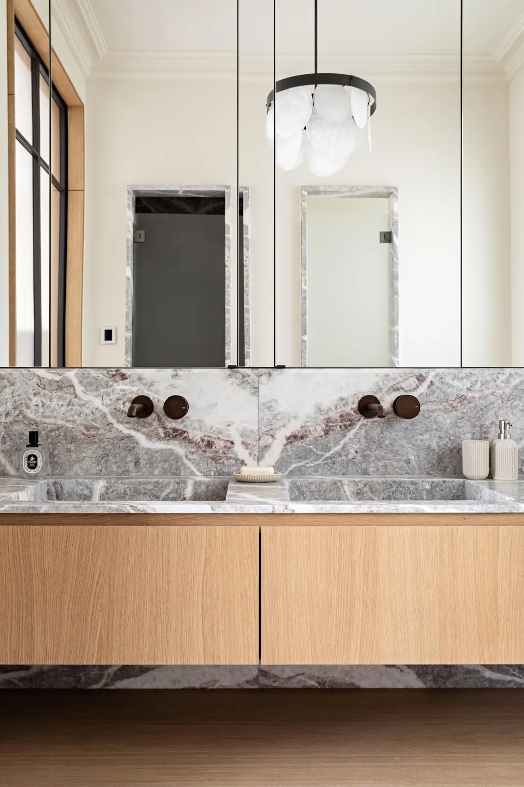 Aménagement intérieur – Salle de bain lumineuse avec meuble bois et miroir rond – Projet Paix CTEG