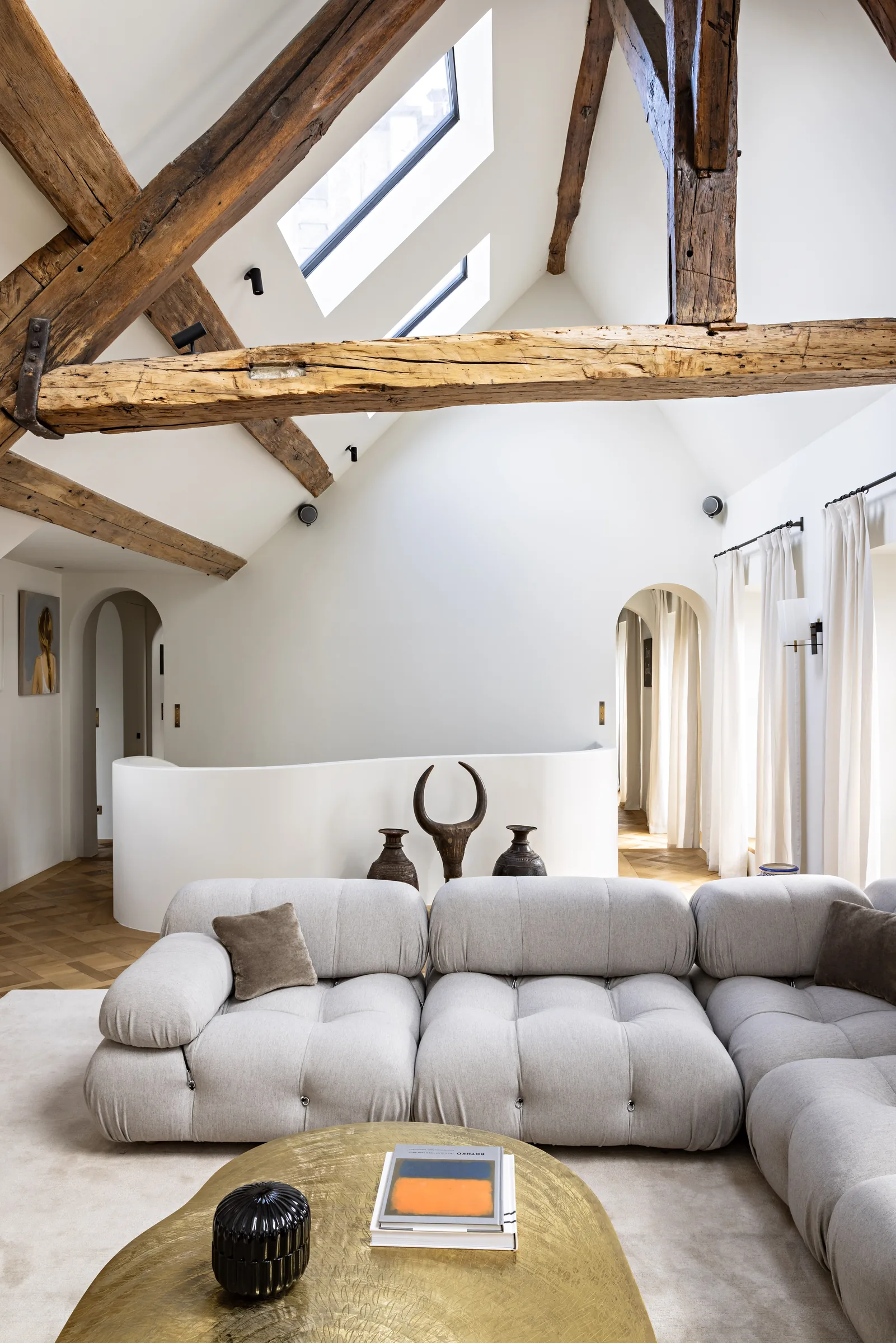 Salon lumineux avec canapé et fenêtres de toit, rénovation d'appartement à Saint-Germain, Paris par CETEG