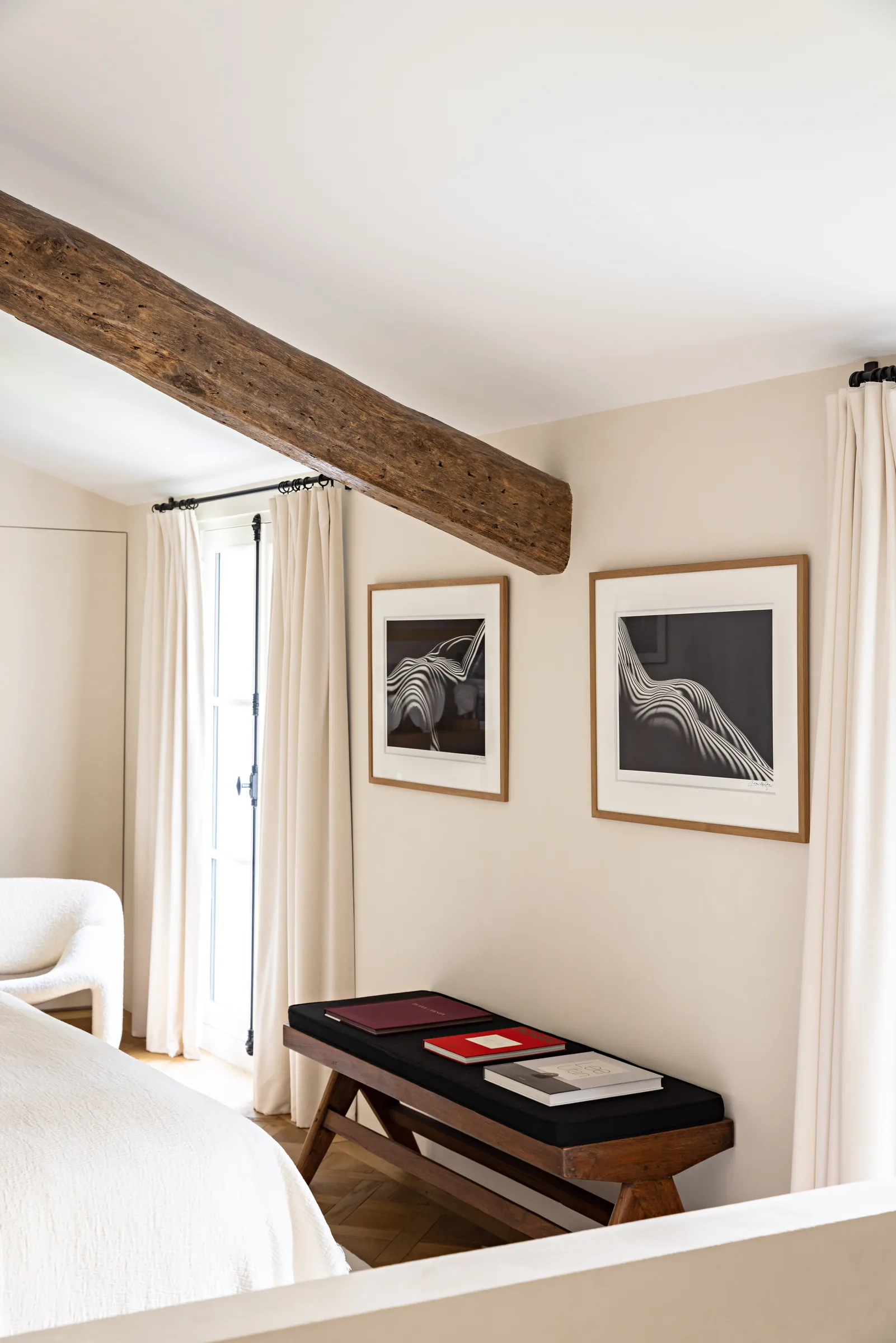 Chambre lumineuse avec banc et œuvre encadrée, appartement haussmannien rénové Saint-Germain, Paris