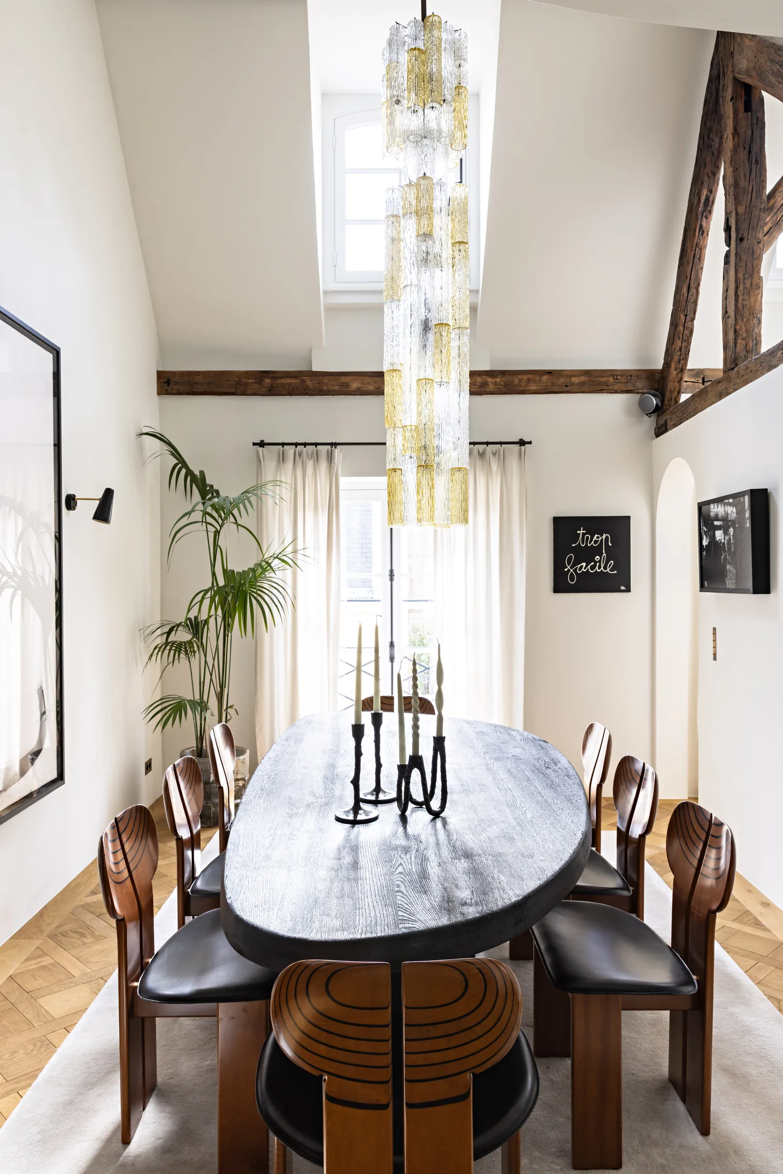 Salle à manger sous combles avec table ronde et suspensions, rénovation Saint-Germain, Paris par CETEG