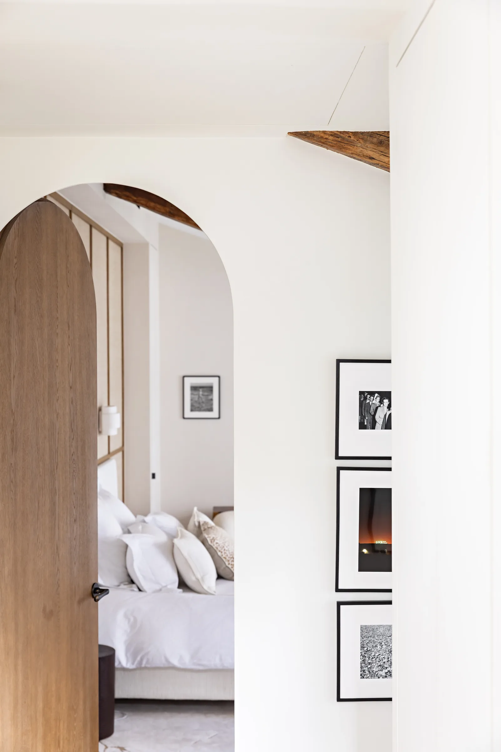 Dégagement avec porte cintrée en bois vers une chambre, appartement haussmannien rénové Saint-Germain, Paris