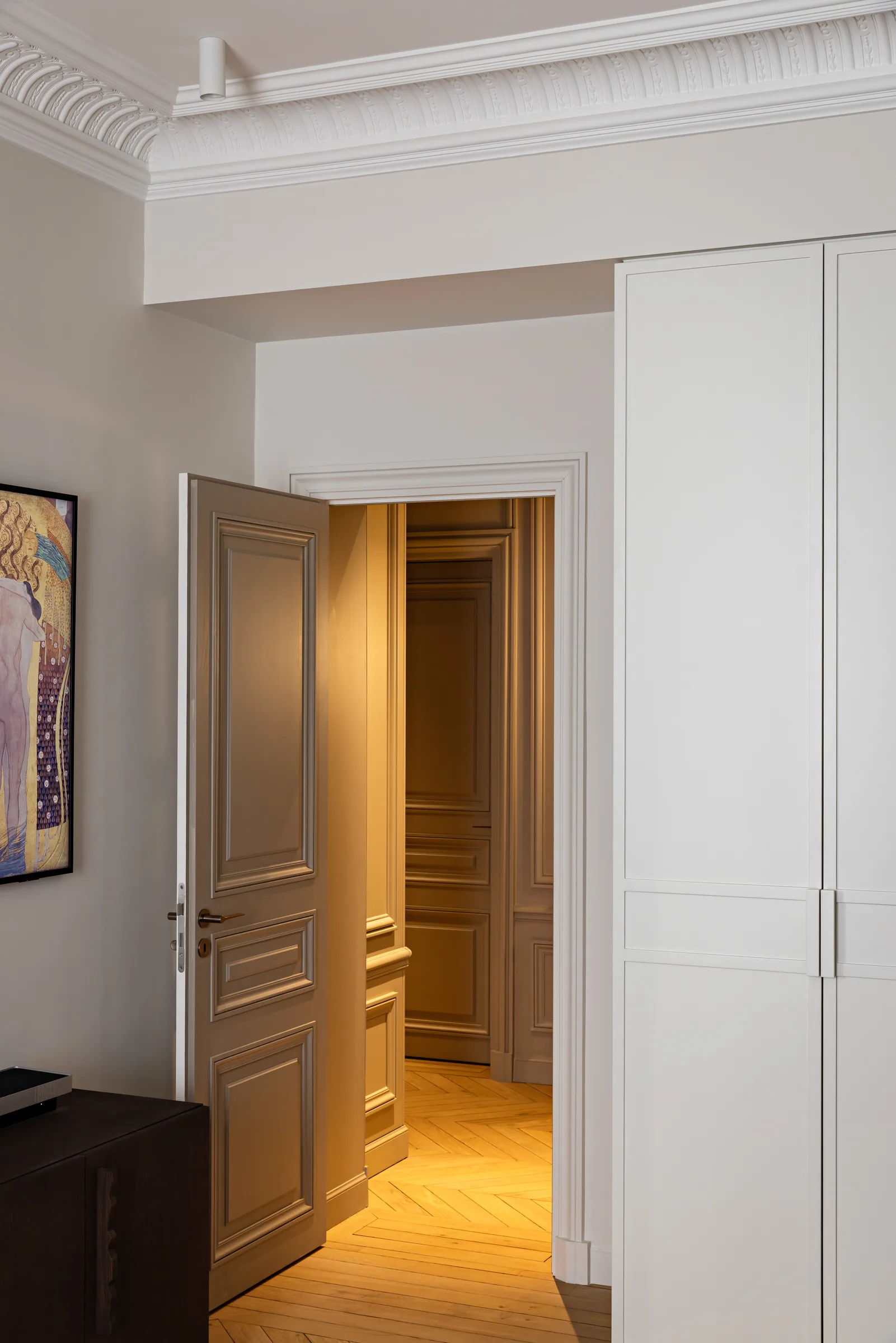 Couloir menant à une pièce baignée de lumière, appartement haussmannien rénové à Paris par CETEG