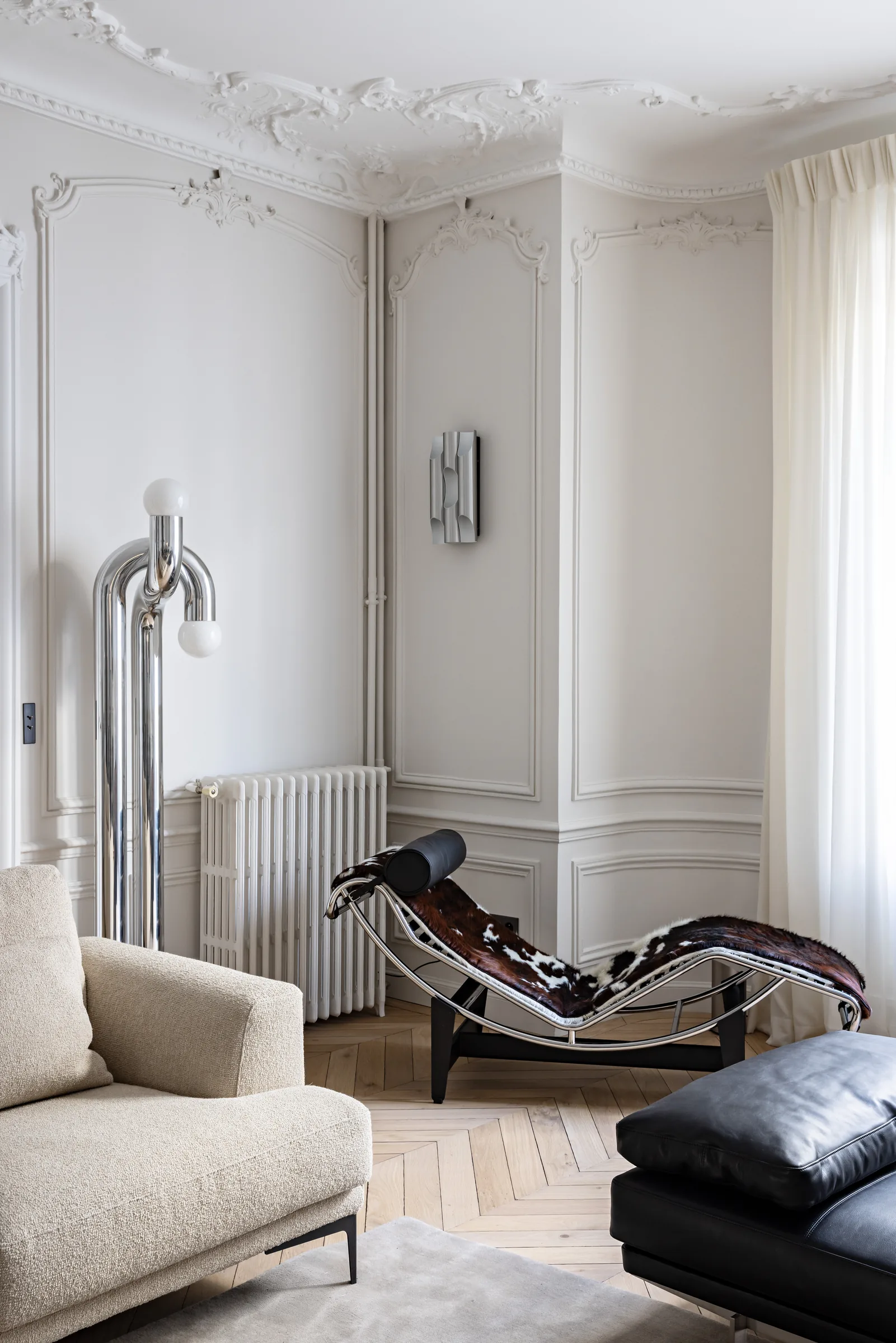 Salon avec chaise longue design et cheminée, rénovation d'appartement haussmannien à Paris par CETEG