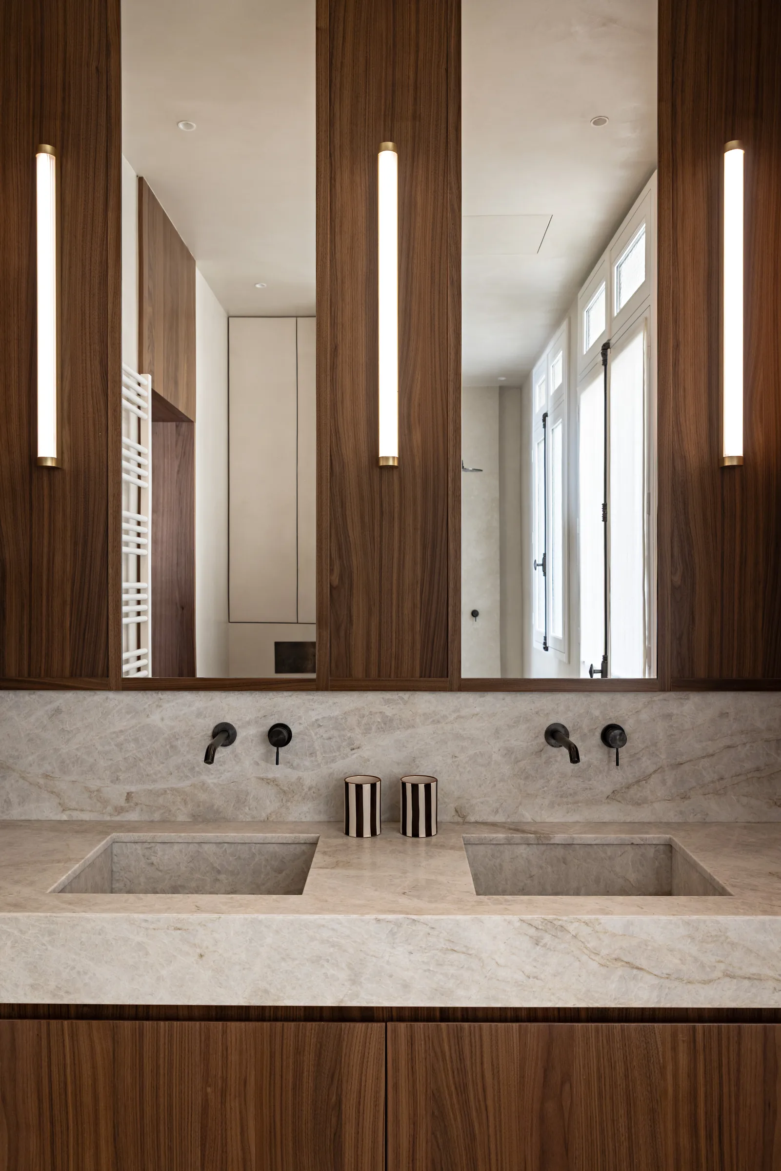 Salle de bains en pierre avec double vasque, rénovation d'appartement haussmannien à Paris