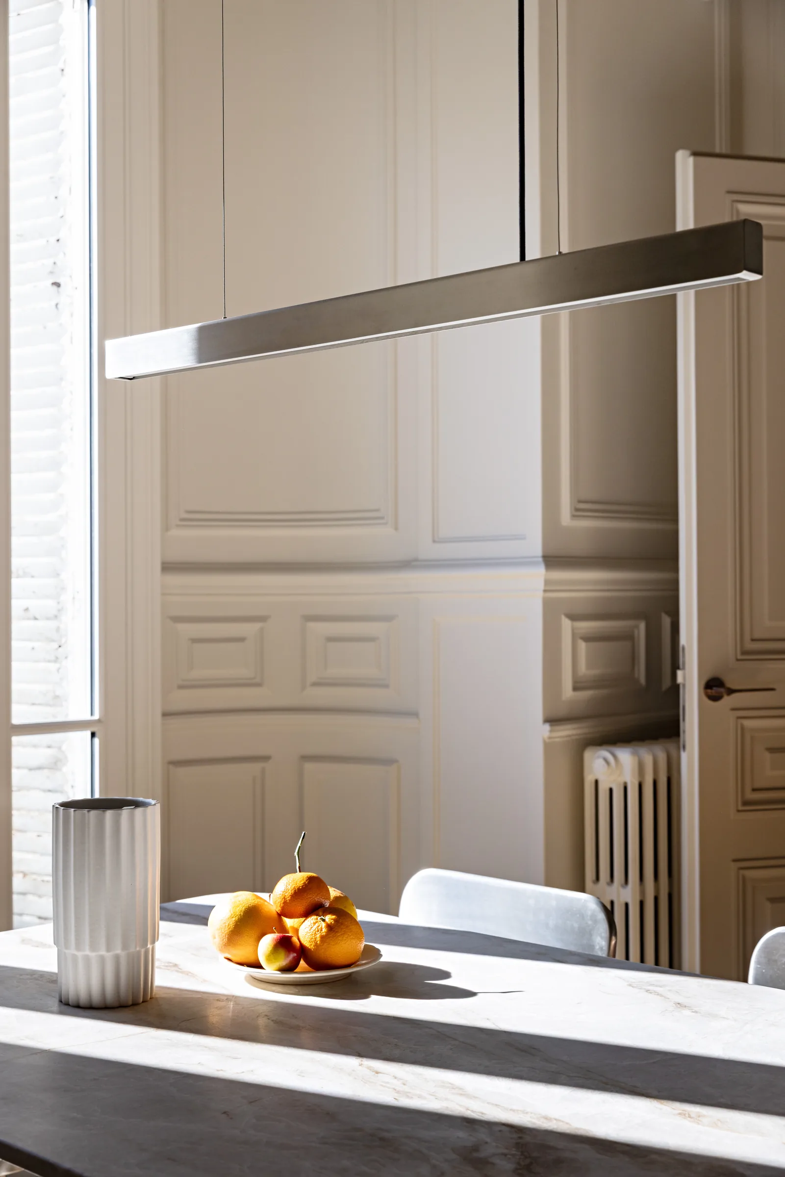 Plan en marbre avec suspension design et vue sur l'extérieur, cuisine d'un appartement haussmannien à Paris
