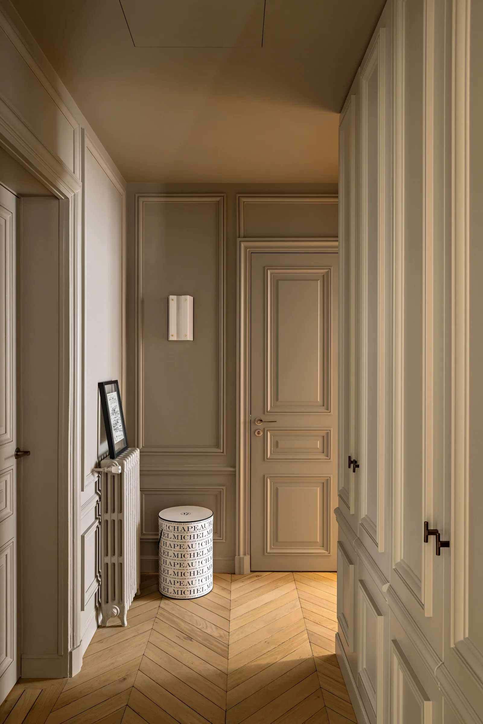 Dégagement avec portes en bois et parquet, appartement haussmannien rénové à Paris