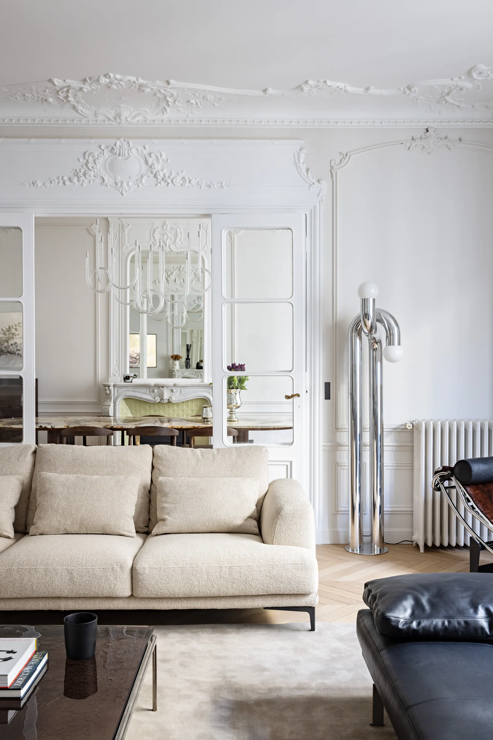 Salon lumineux avec banquette en cuir et parquet, appartement haussmannien rénové par CETEG à Paris