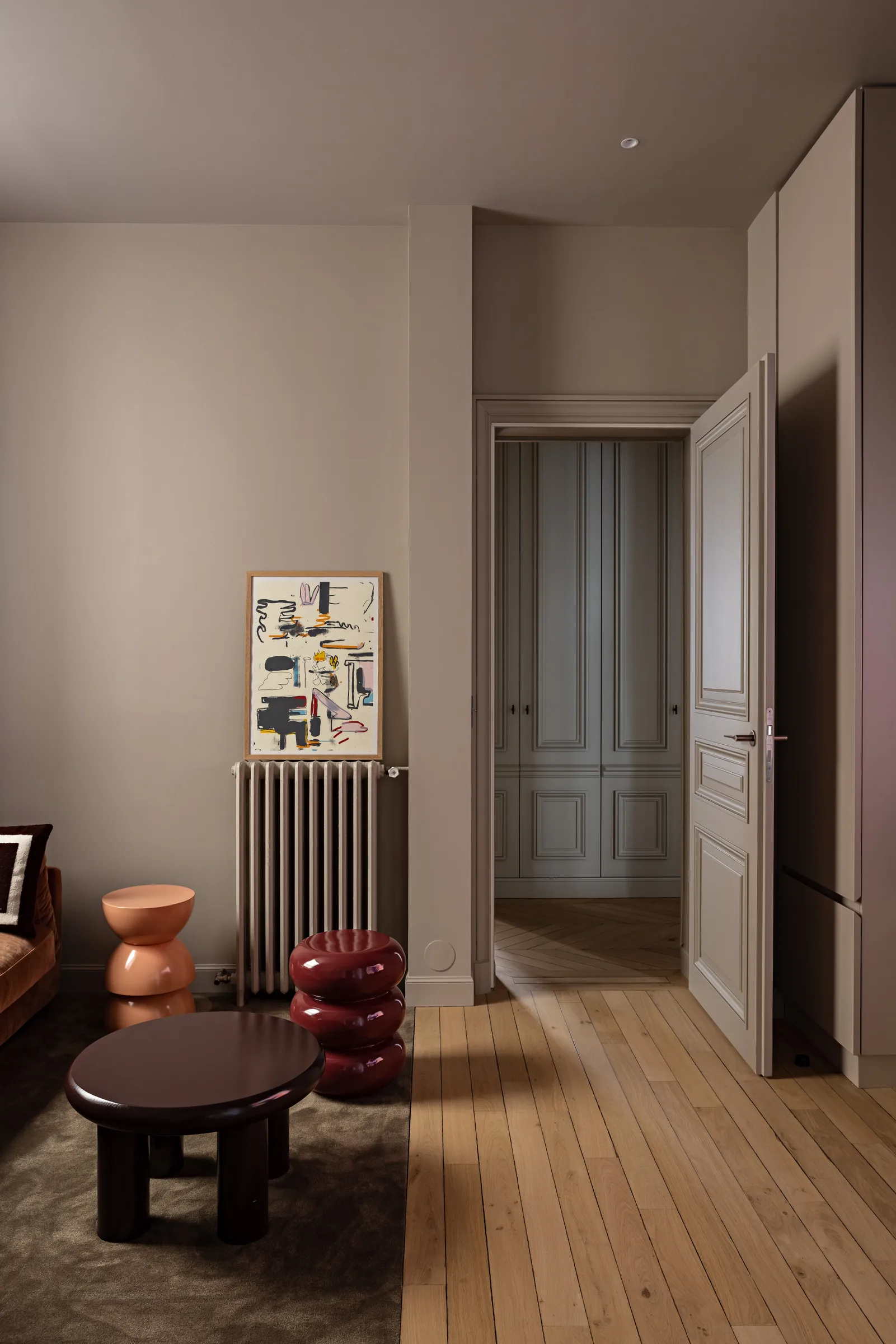 Coin salon avec table basse ronde et tabourets design, appartement haussmannien rénové à Paris