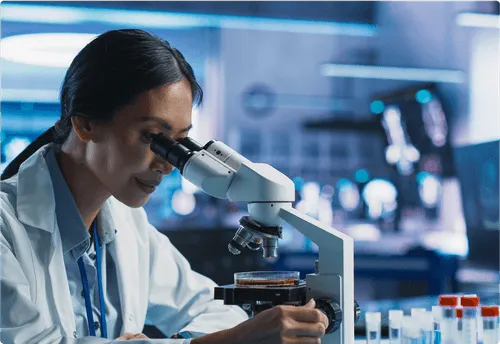 A doctor examines samples with a microscope in a lab.