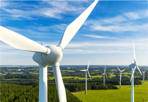 Aerial view of white wind turbines in a green field.