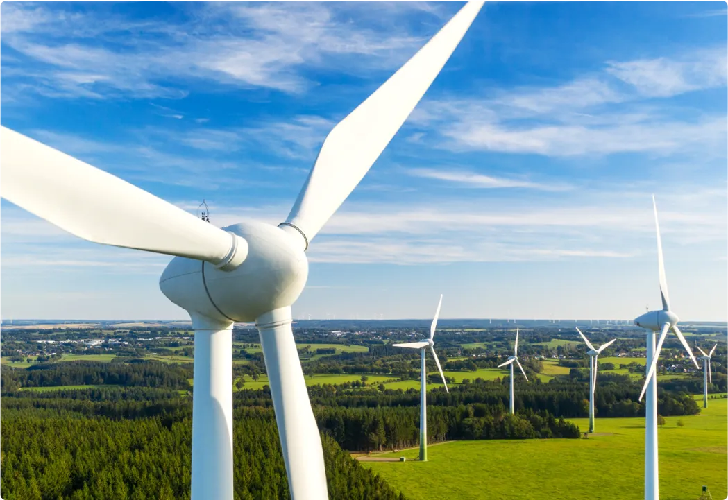 Aerial view of white wind turbines in a green field.
