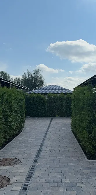 Доріжка серед підстрижених кущів на території Harmony-Cottage