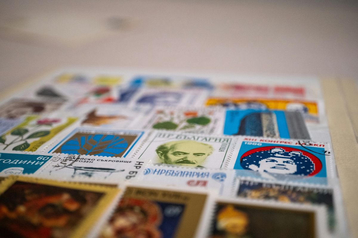 Nahaufnahme bunter Briefmarken verschiedener Länder, klassische Philatelie trifft auf das digitale Zeitalter des Online Frankierens.