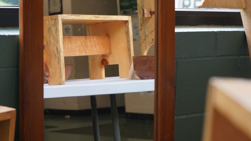 Image of a custom mirror reflecting projects in the workshop.