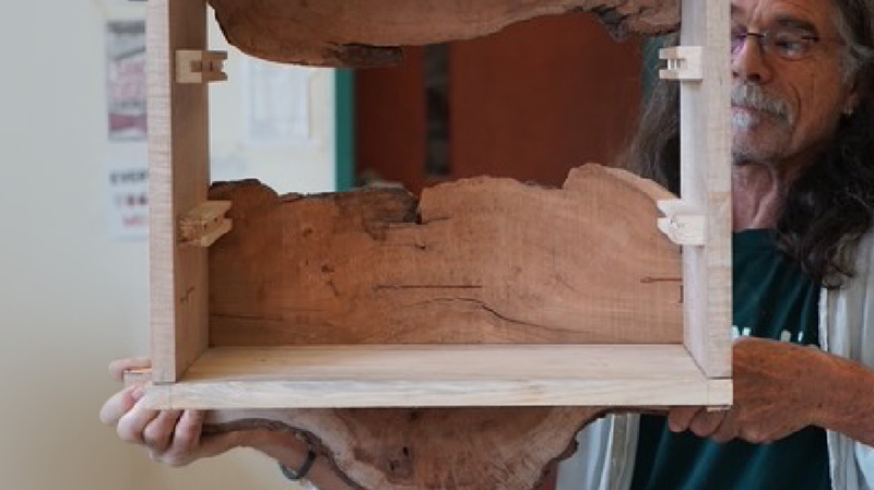 Image of a teacher holding up a custom reclaimed shelf.