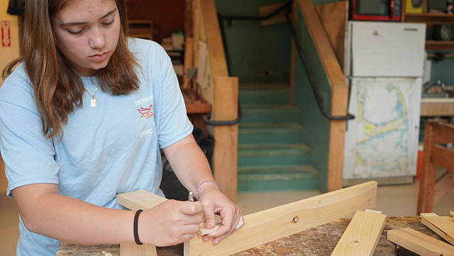 A student marking pieces of a woodworking project