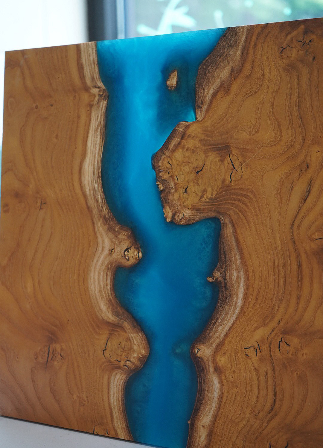 Beautiful piece of live edge wood with blue resin between the two sides.