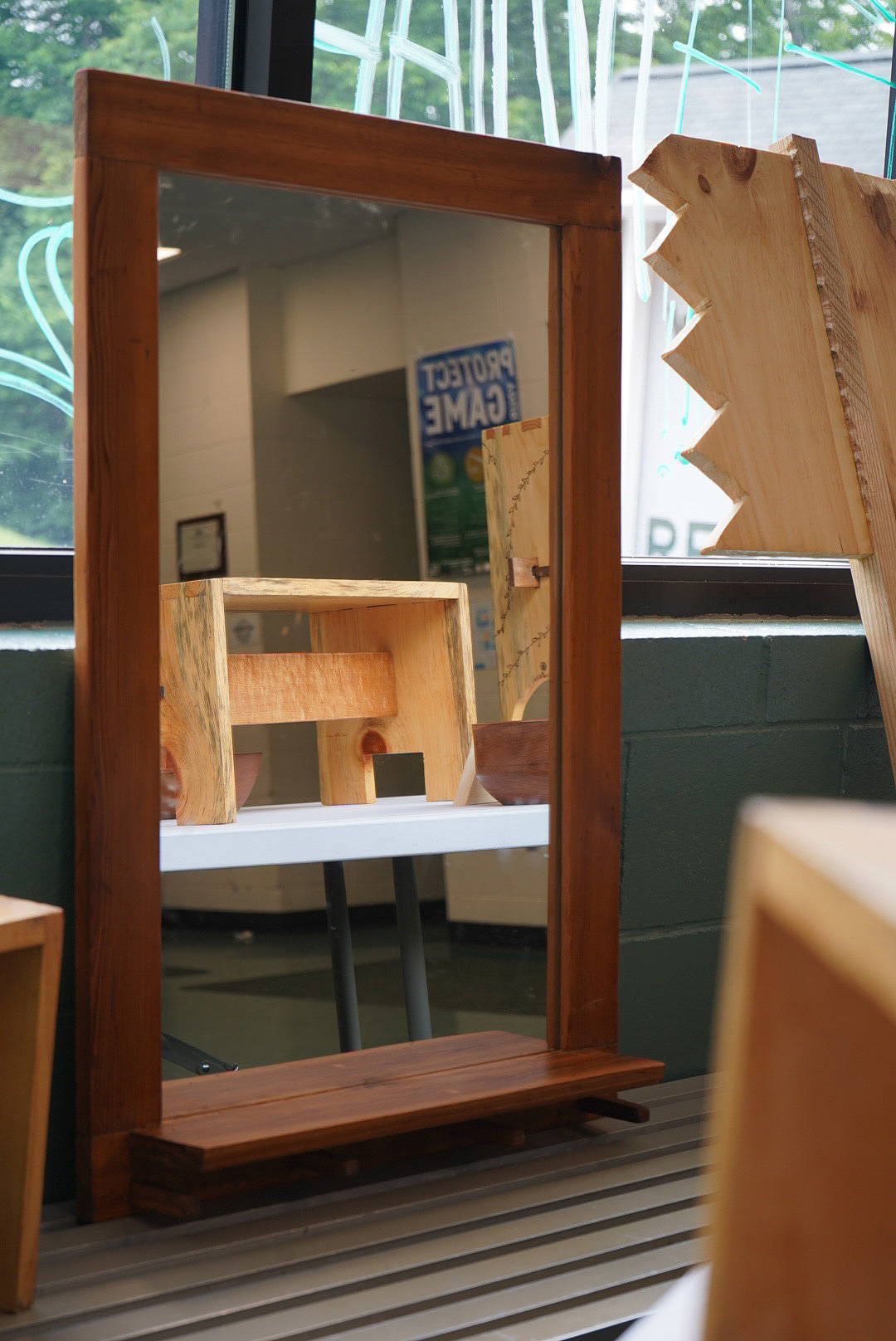 A handcrafted, large mirror with shelf built into the frame.