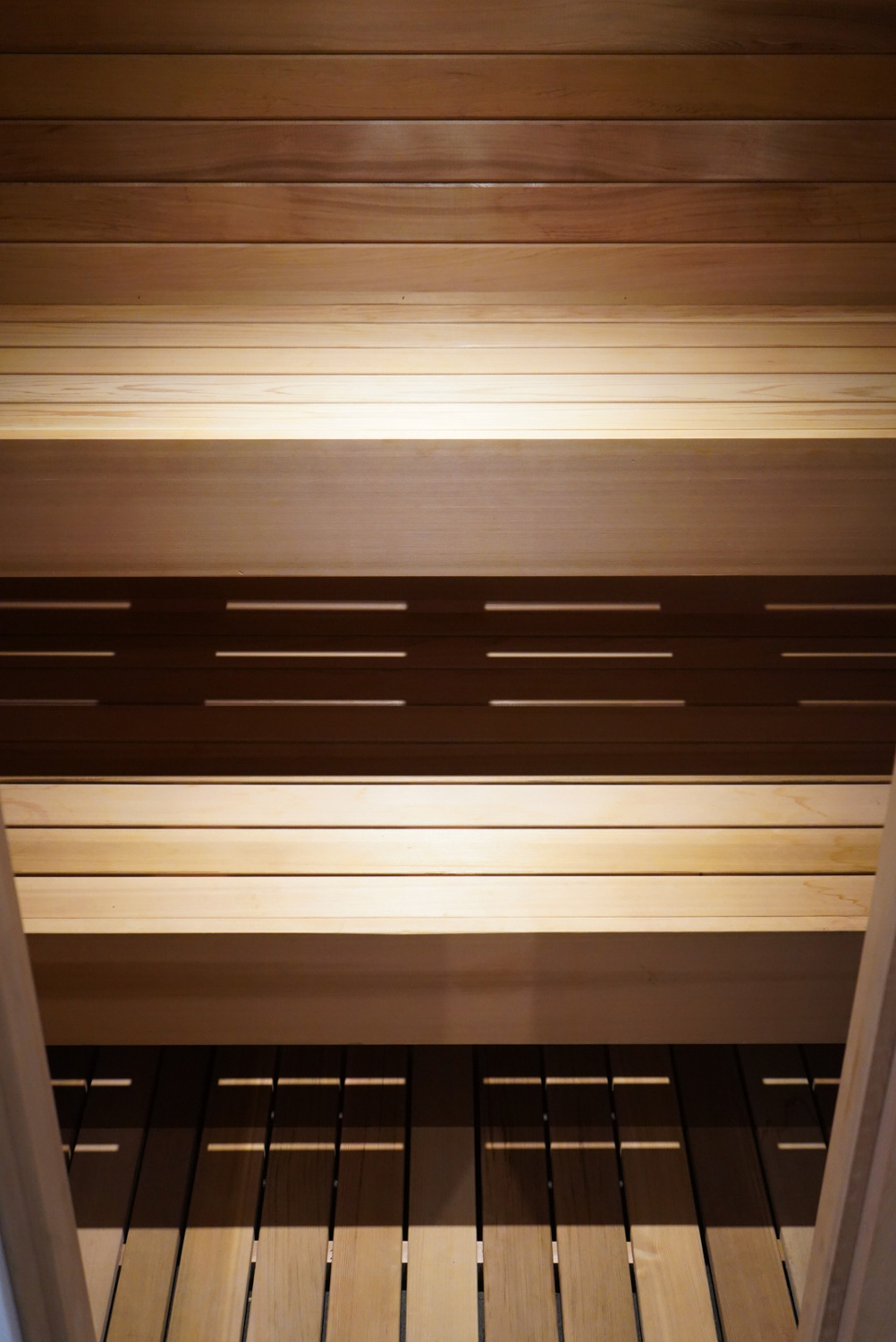 Project detail: Close up inside of sauna, looking down at bench and floor.