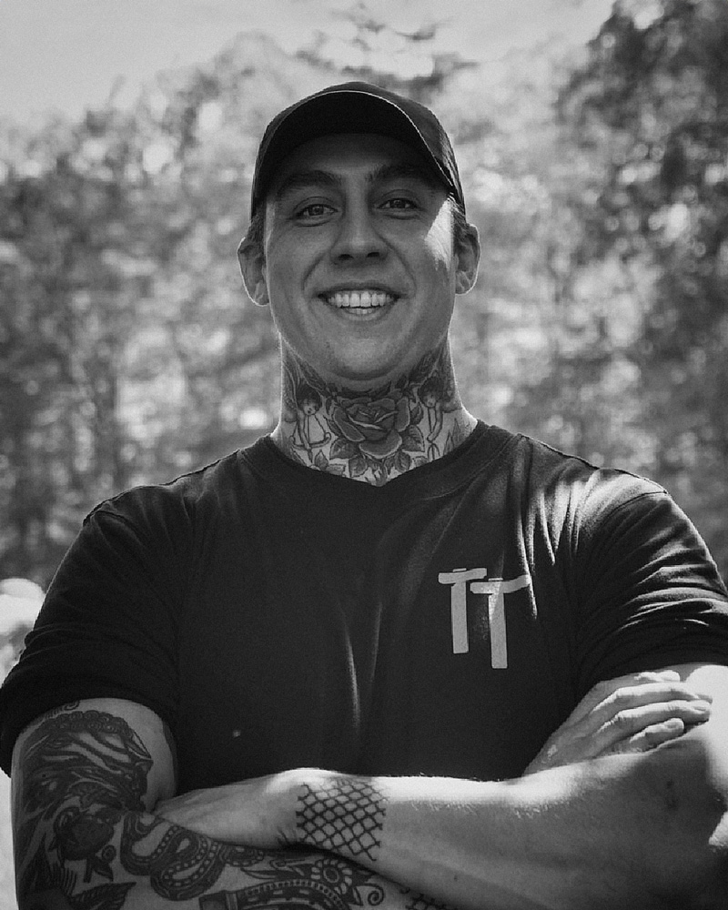 Black and white portrait of Forest Taylor. Trees behind.