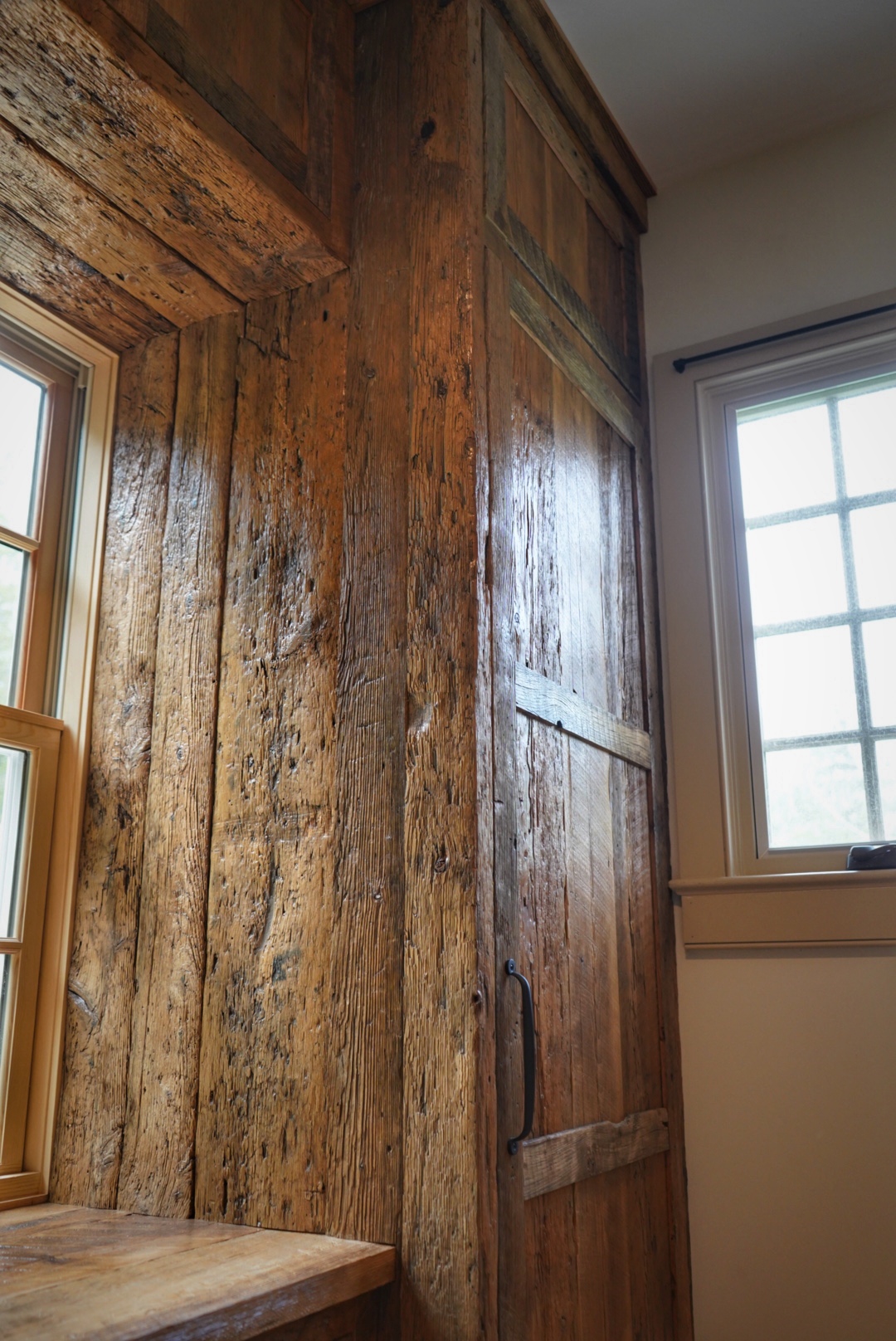 Project detail: Close up of right side of reclaimed cabinetry, inside near the window.
