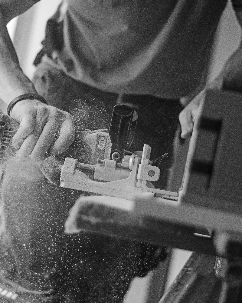 Close up, black and white image of a person using a saw.