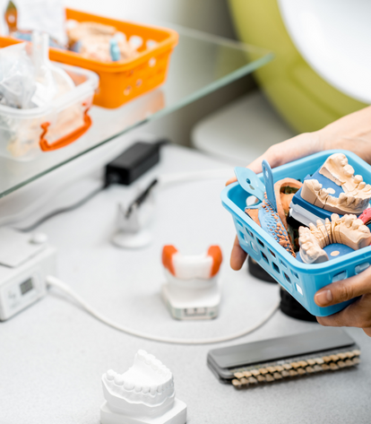 technician holds basket of dental molds