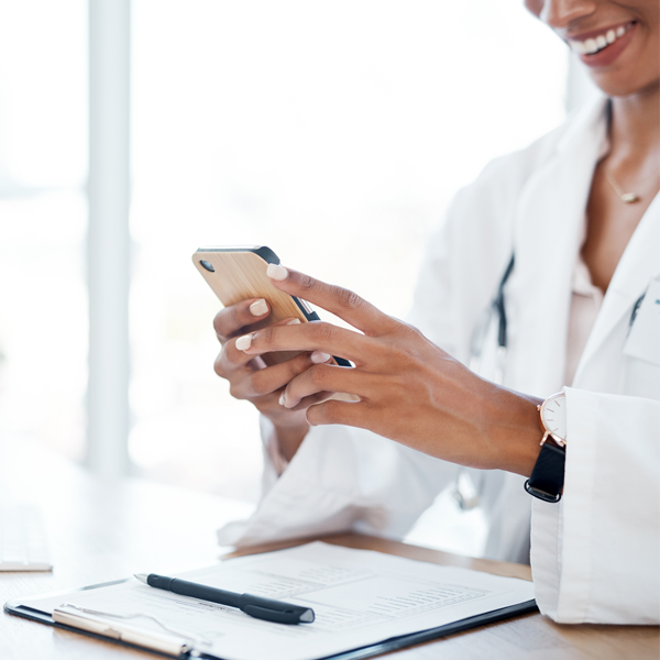 doctor checks phone at desk