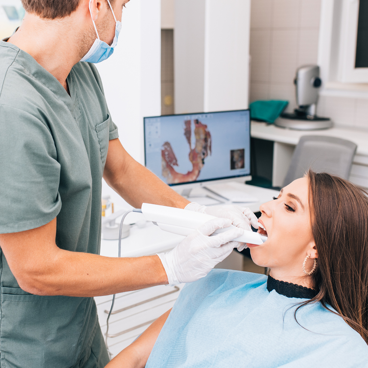 dentist uses oral scanner on patient