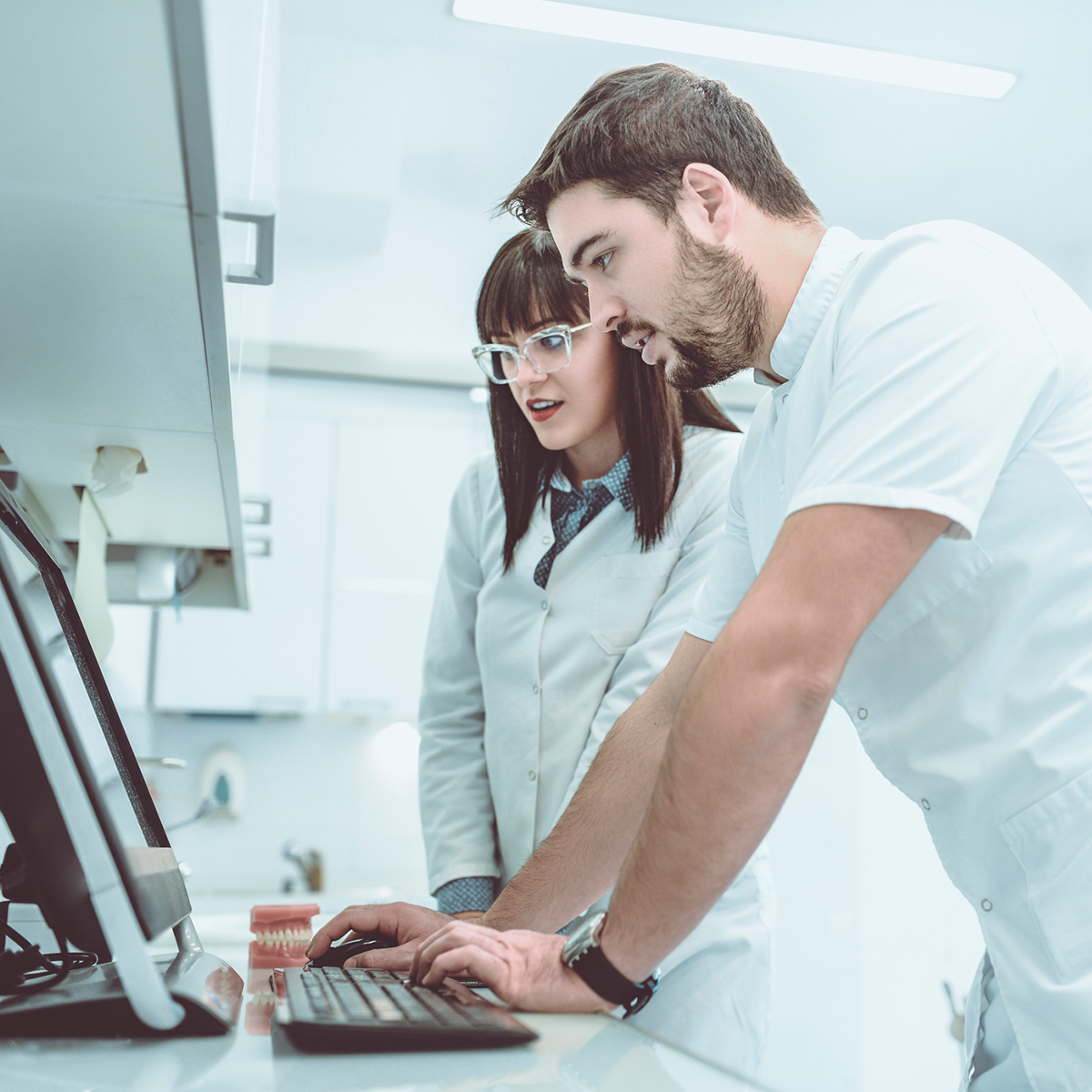dental lab assistant and technician working in laboratory