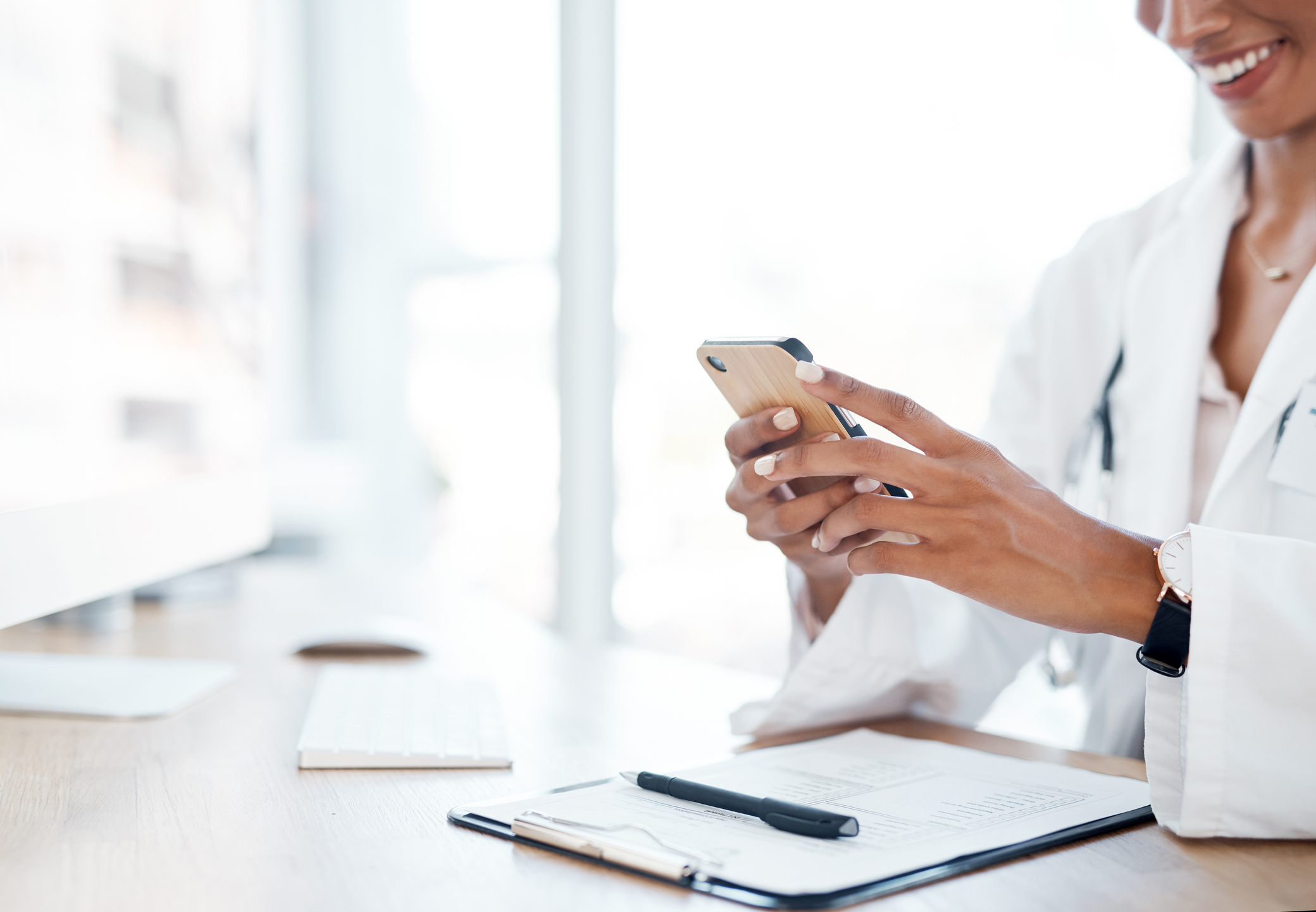 doctor uses phone while reviewing papers