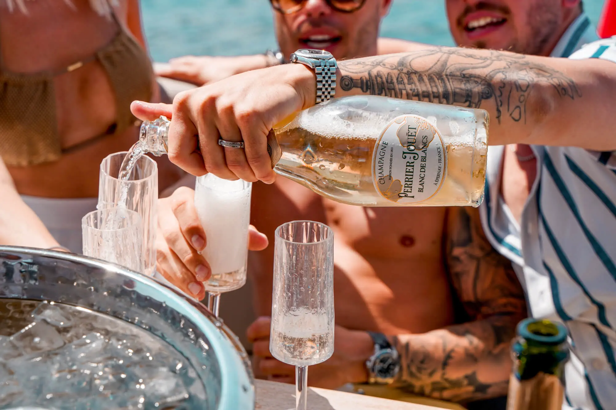 Young people having fun on a yacht, drinking champagne during a bachelor party.