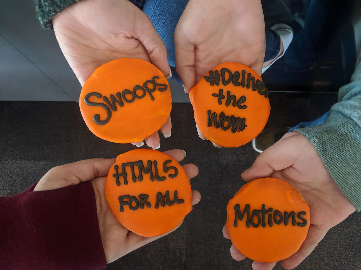 Cookies with orange frosting stating swoops, html5 for all, motions, and #deliver the wow, for Sojern's release of html5 ads for all customers.