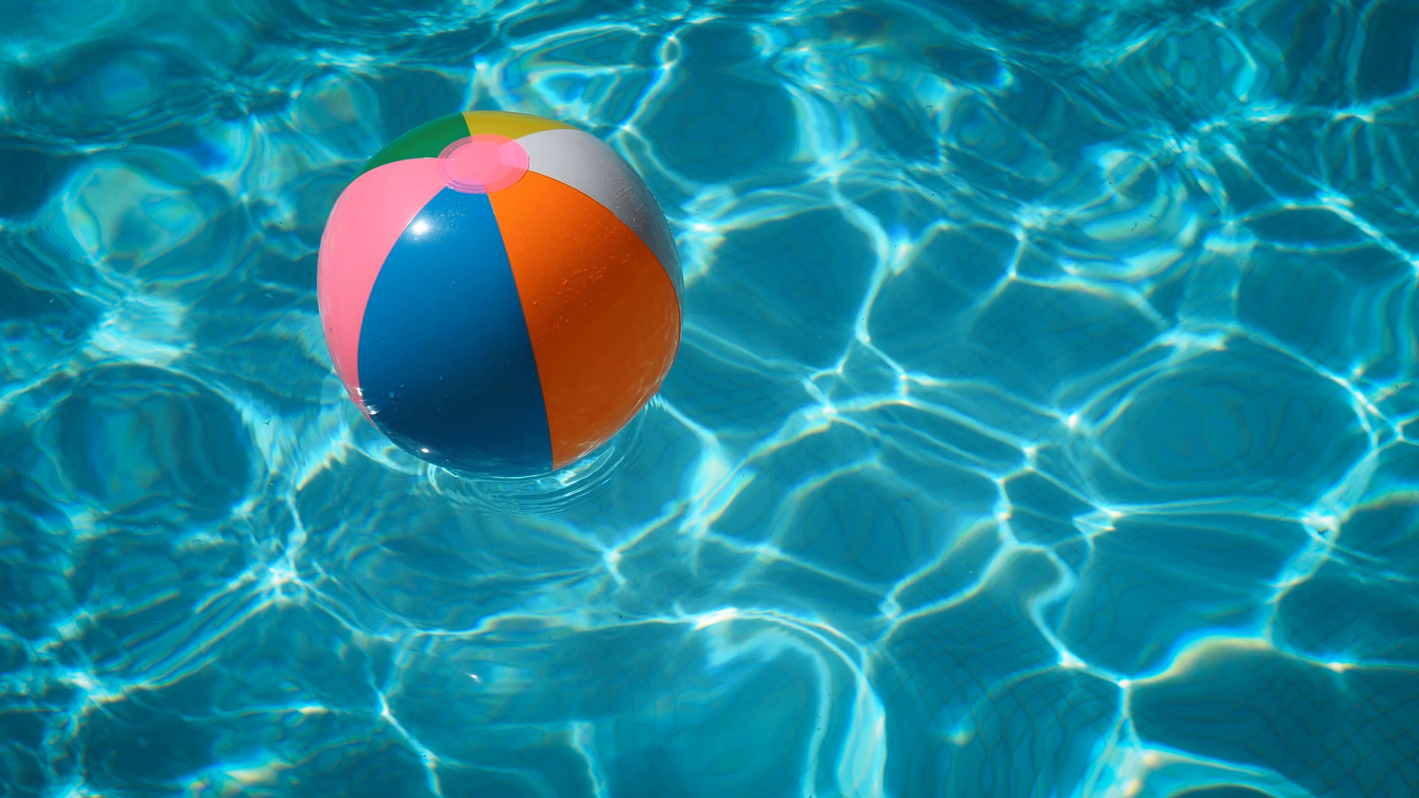 Colorful beach ball floating in a pool.