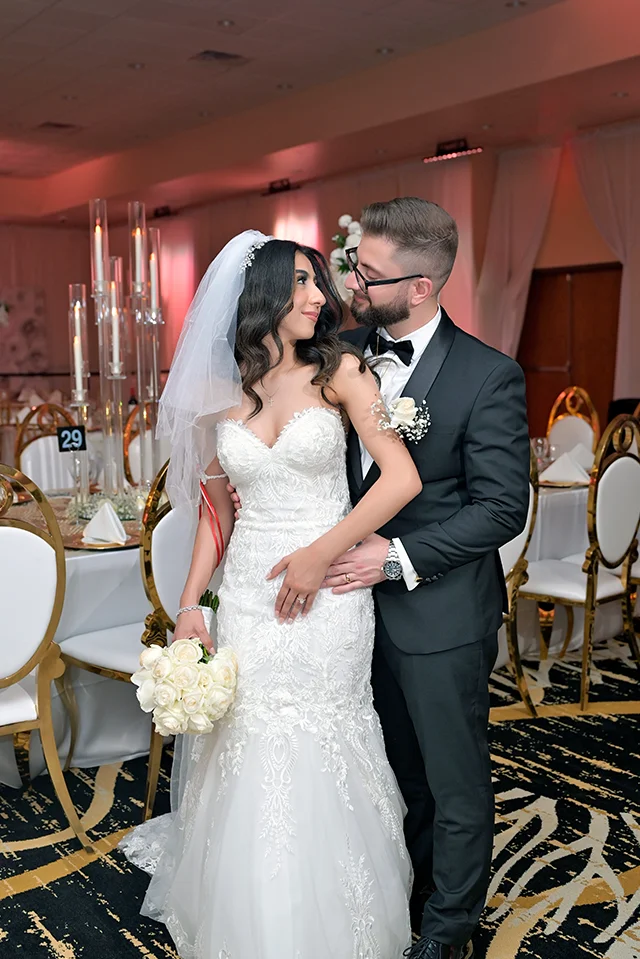 A married couple in a reception hall looking at each other 