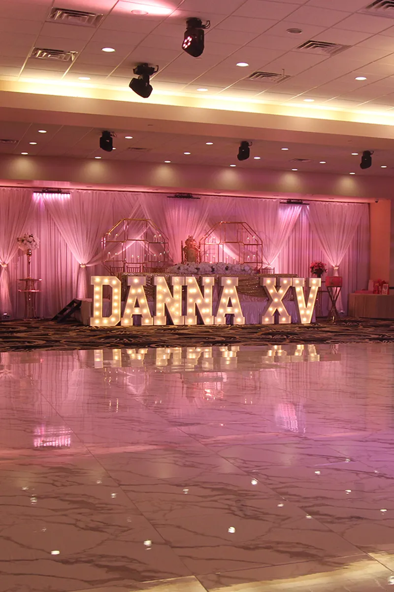 Venue Ballroom with Quinceañera's Name in Front of Head Table