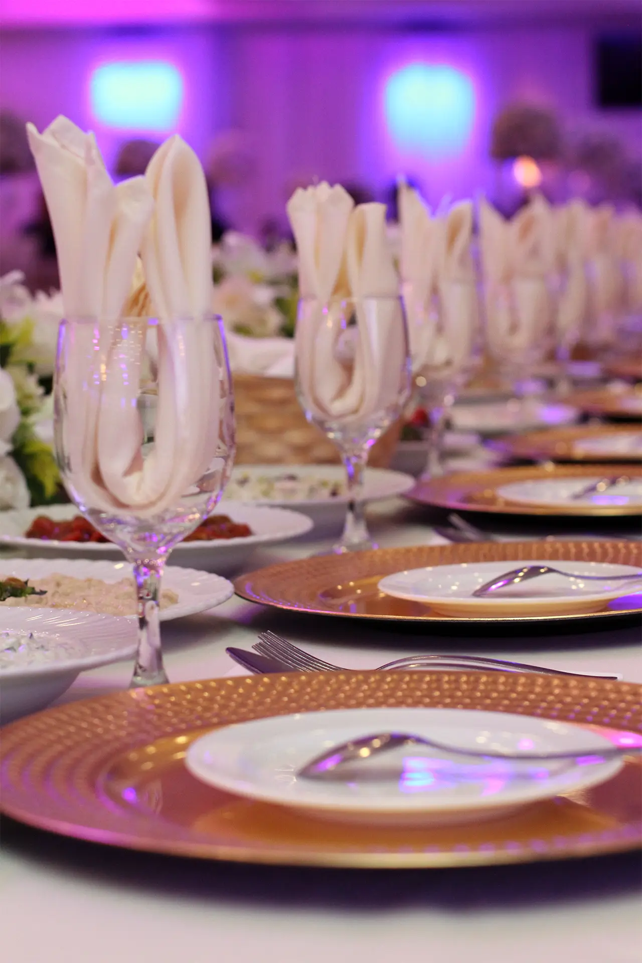 Closeup of Decorated Head Table Plates, Glasses, and Silverware