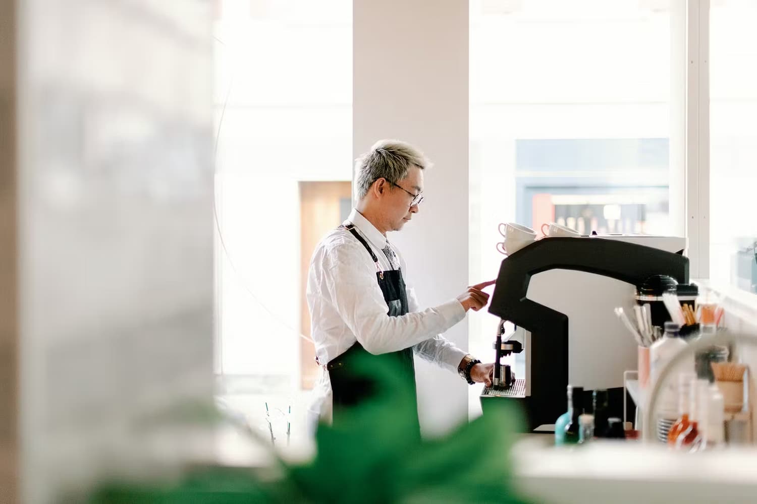 Barista working behind a coffee machine. 