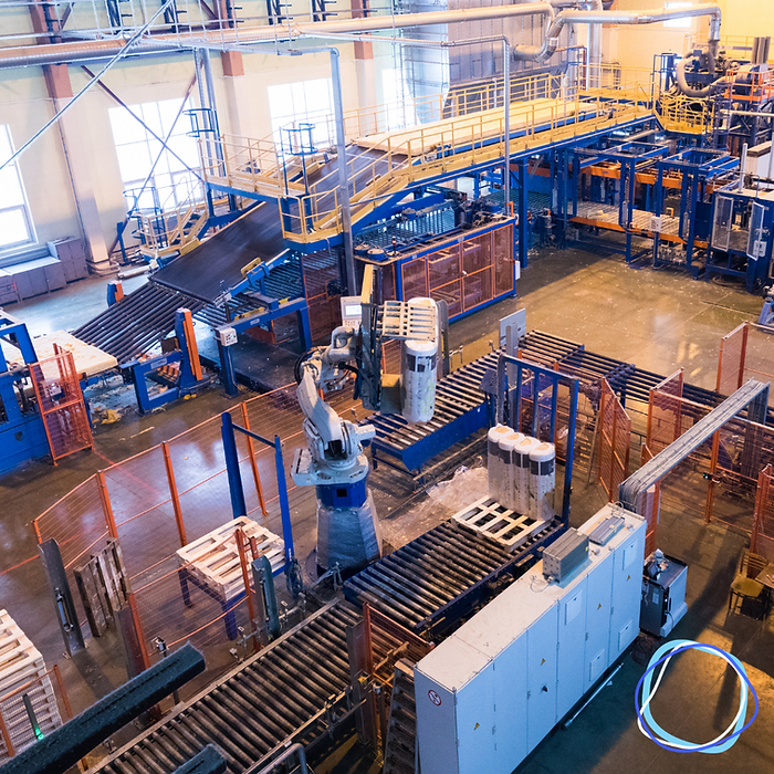 Graphic that shows a factory/warehouse, along with the company logo in the bottom right corner
