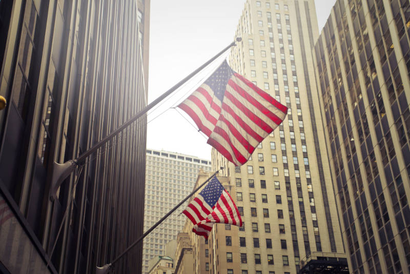 American flags waving among New York skyscrapers